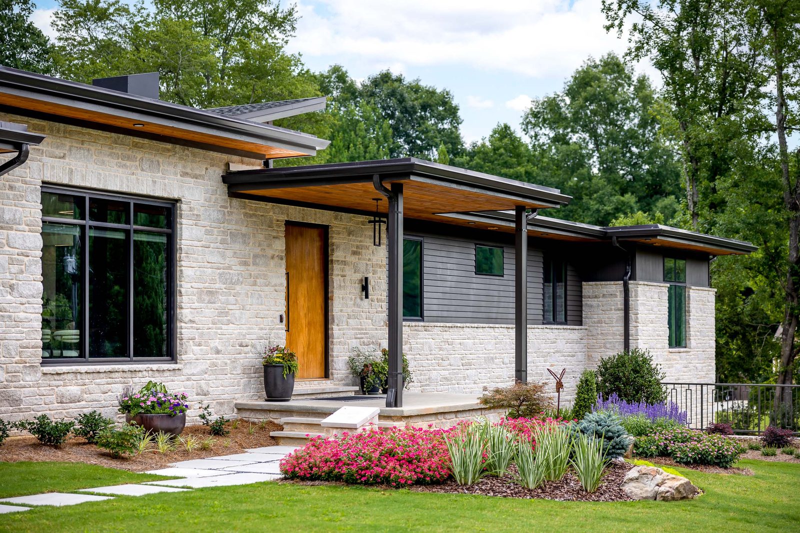 Front entry elevation with stone and flowering beds — The Ortiz Home, custom home built by Ironwood Construction Group in Sugar Hill, Georgia